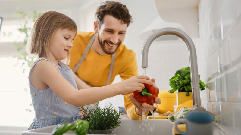 Father and daughter washing fruit